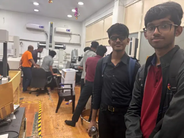Team members at the competition venue in black shirts beside the pit table