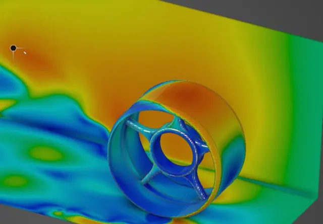 CFD render of a wheel on the ground plane, pressure contours from blue to red