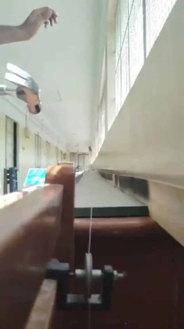 A frame from the wheel test rig video: a wheel spinning on a rail by a window