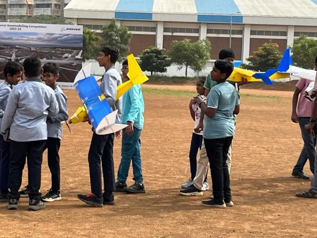 Teams on a dusty playing field at IIT Madras holding their aircraft